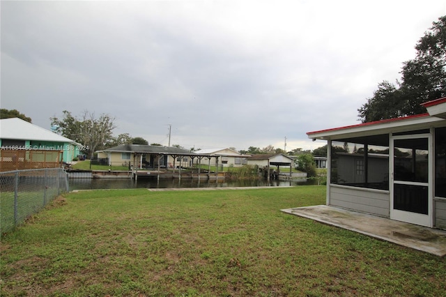 view of yard featuring a water view and a boat dock