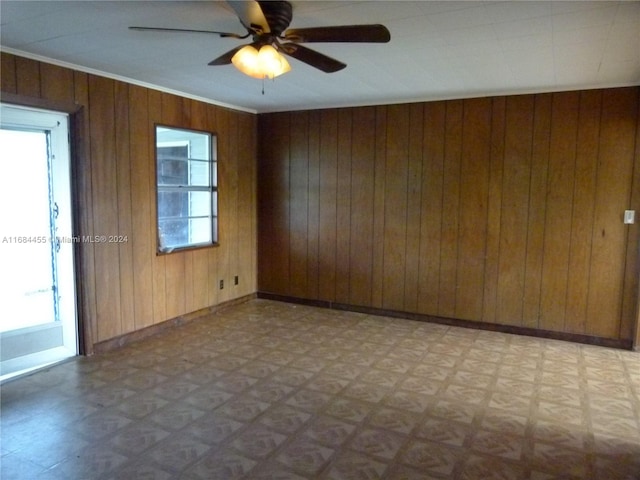 empty room featuring wooden walls and ceiling fan