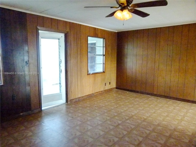 spare room featuring wooden walls and ceiling fan