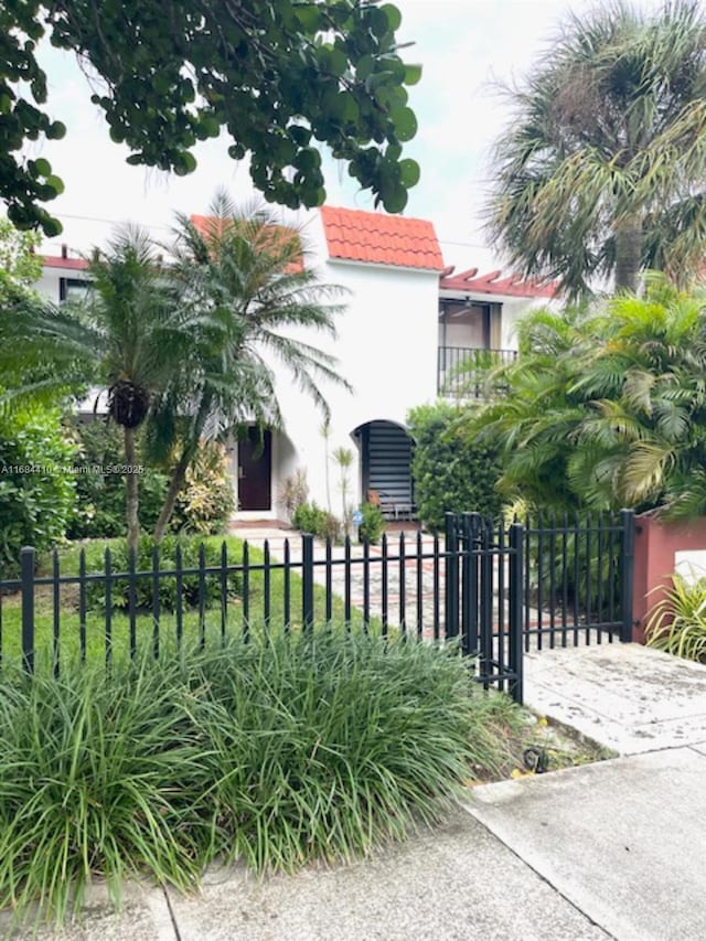 265 Grapetree Dr Unit 108, Key Biscayne, FL 33149 - view of side of home with a tiled roof, stucco siding, and a fenced front yard