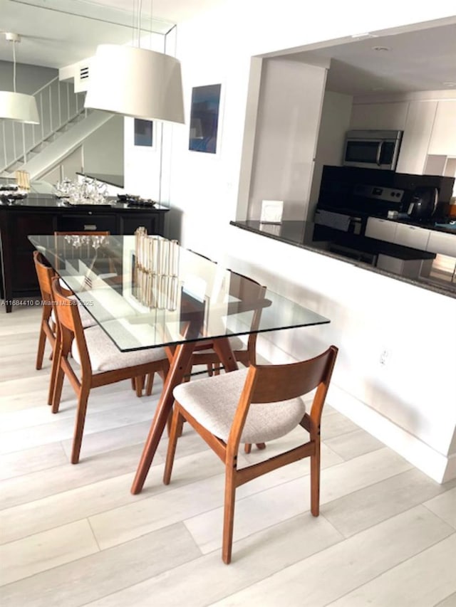 dining space with light hardwood / wood-style floors