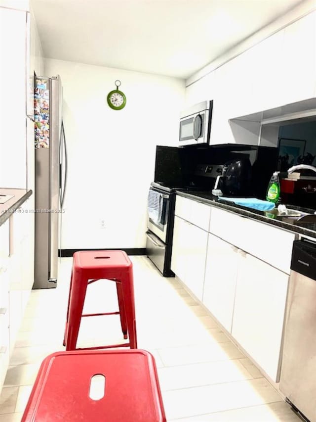 kitchen with stainless steel appliances, sink, and white cabinets