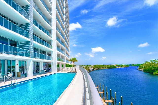 view of pool featuring a patio area and a water view