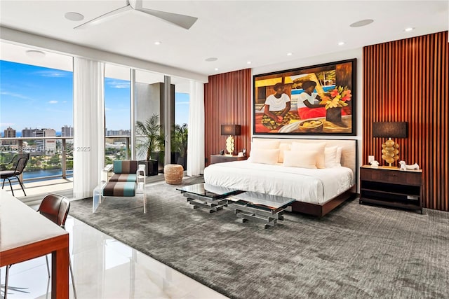 bedroom with a water view, access to outside, and expansive windows