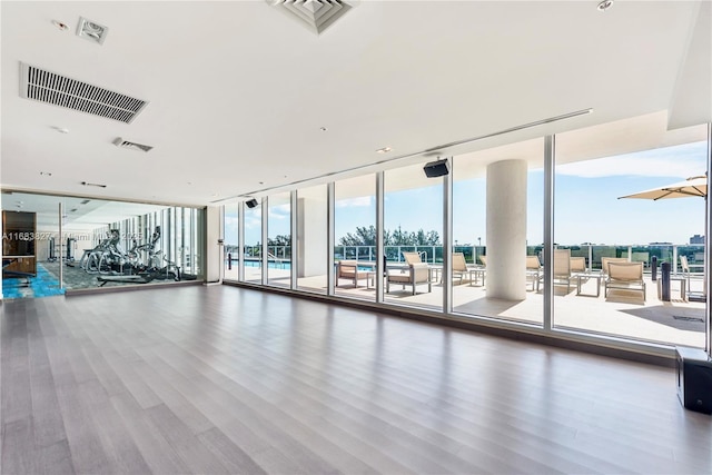 gym featuring hardwood / wood-style flooring and expansive windows