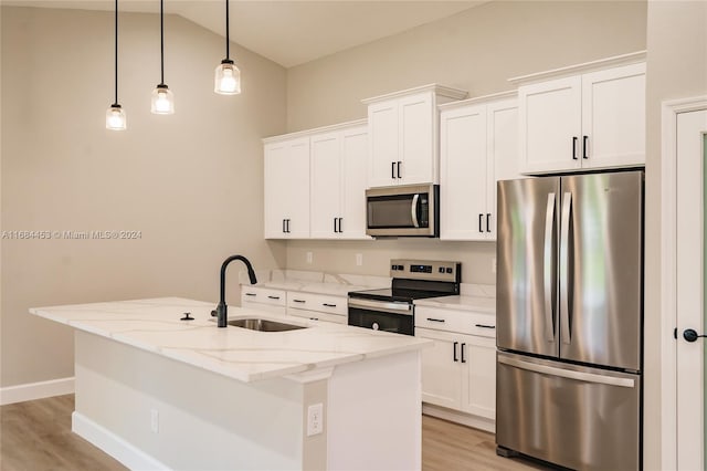 kitchen featuring a kitchen island with sink, sink, light stone countertops, pendant lighting, and appliances with stainless steel finishes