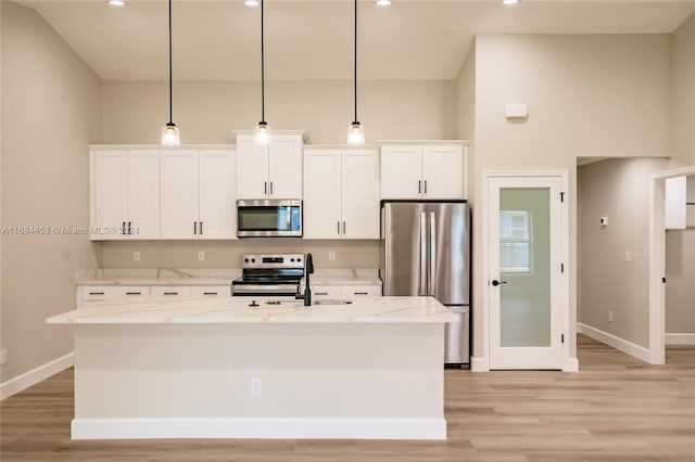 kitchen with appliances with stainless steel finishes, light stone countertops, and hanging light fixtures