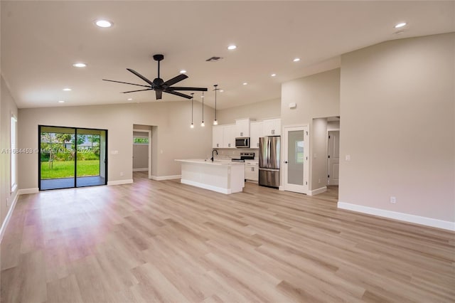 unfurnished living room with lofted ceiling, sink, light wood-type flooring, and ceiling fan