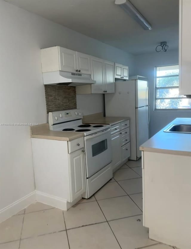 kitchen featuring white appliances, light tile patterned floors, white cabinetry, and sink