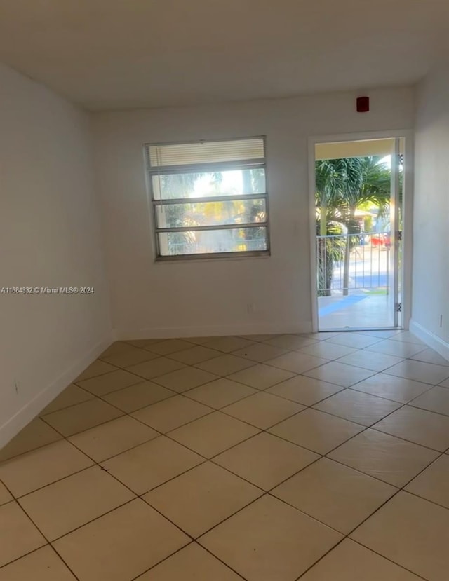 tiled empty room featuring a healthy amount of sunlight