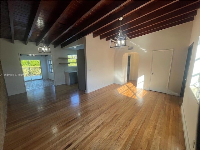 empty room featuring a notable chandelier, vaulted ceiling with beams, wood-type flooring, and wooden ceiling