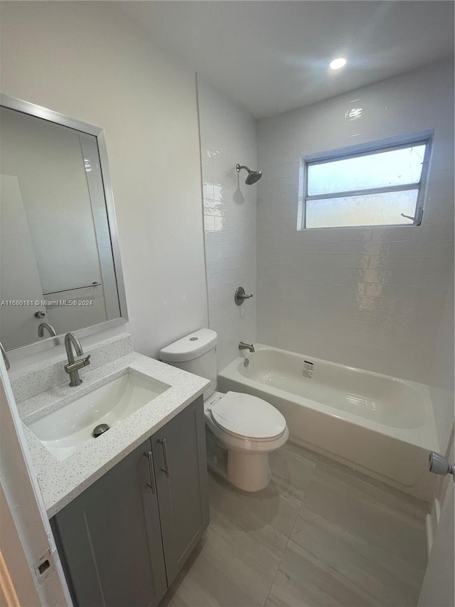 full bathroom with vanity, tiled shower / bath combo, and toilet