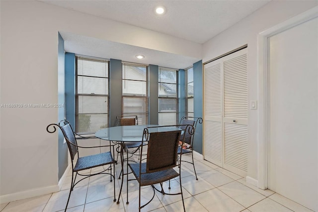 tiled dining room with a textured ceiling and a healthy amount of sunlight