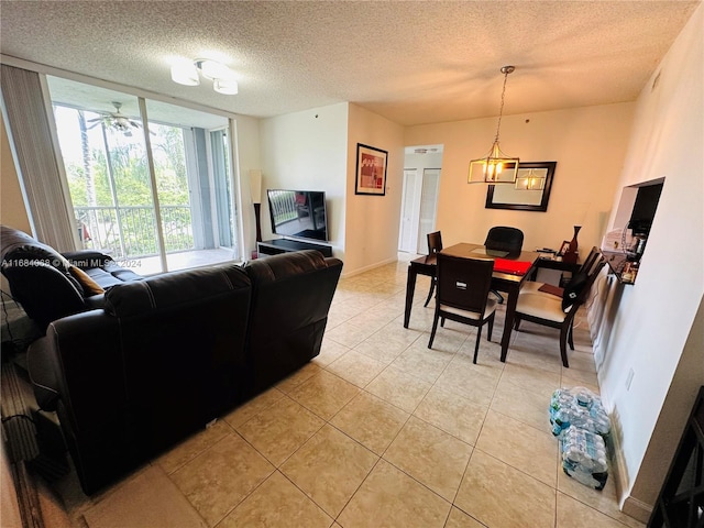 living room with a textured ceiling, light tile patterned flooring, and ceiling fan with notable chandelier