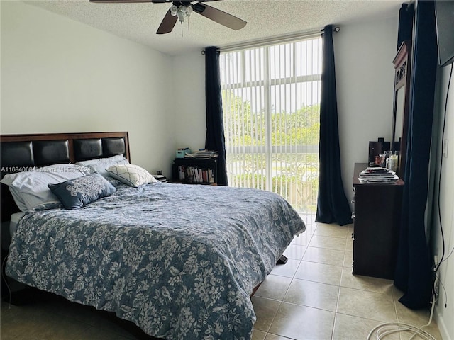 bedroom with a textured ceiling, ceiling fan, and light tile patterned flooring