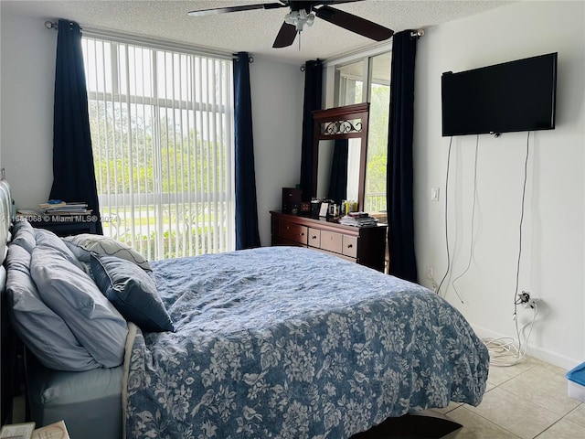 bedroom featuring ceiling fan, a textured ceiling, light tile patterned floors, and access to outside