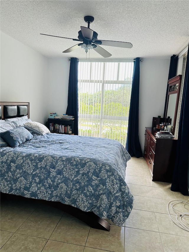 tiled bedroom featuring a textured ceiling and ceiling fan