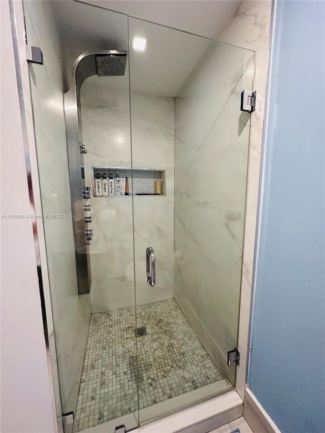 bathroom featuring a shower with shower door