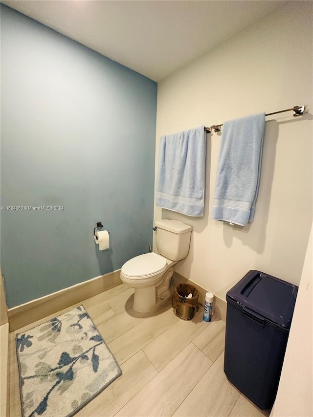 bathroom with toilet and hardwood / wood-style flooring