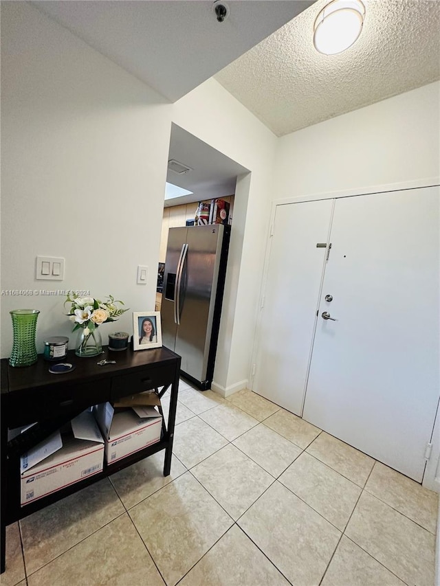 interior space with light tile patterned flooring and a textured ceiling