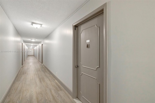 hall featuring a textured ceiling and light wood-type flooring