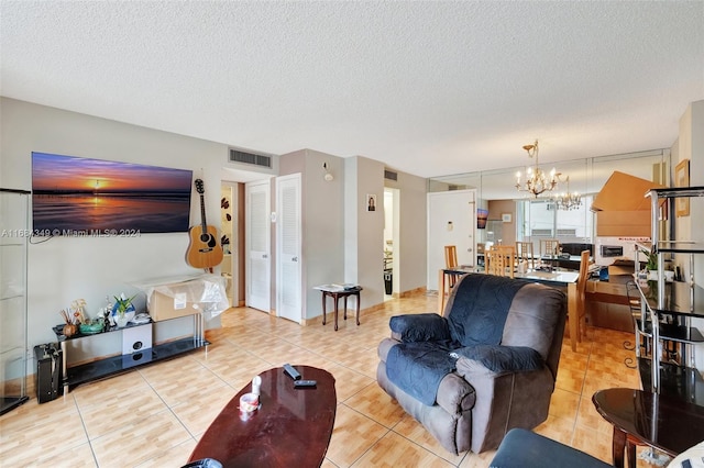 living room with light tile patterned floors, a textured ceiling, and an inviting chandelier