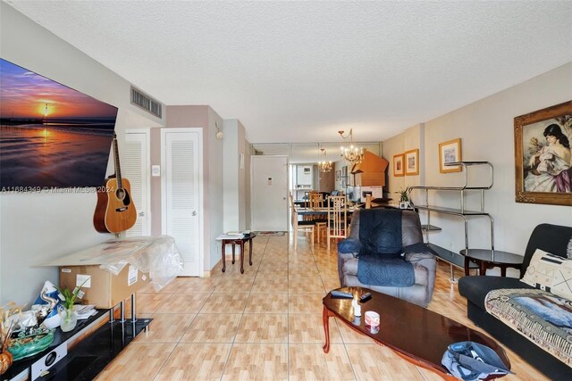 3161 S Ocean Dr Unit 203, Hallandale Beach, FL 33009 - living room with a chandelier, a textured ceiling, baseboards, and light tile patterned floors