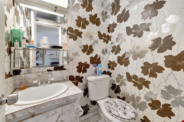 bathroom featuring toilet, vanity, and tile patterned flooring