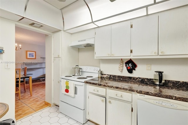 kitchen with dark stone countertops, an inviting chandelier, light wood-type flooring, white cabinets, and white appliances