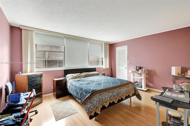 bedroom with a textured ceiling and light wood-type flooring