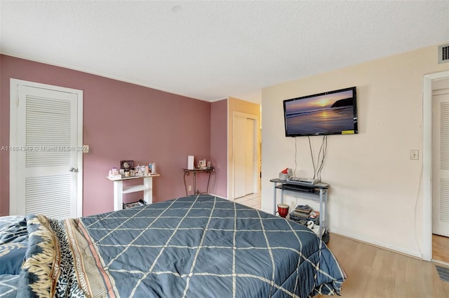 bedroom featuring a textured ceiling and wood-type flooring