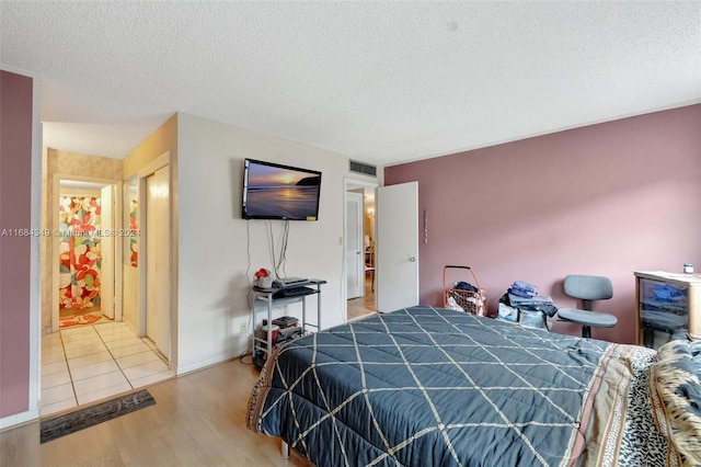 bedroom featuring hardwood / wood-style floors and a textured ceiling