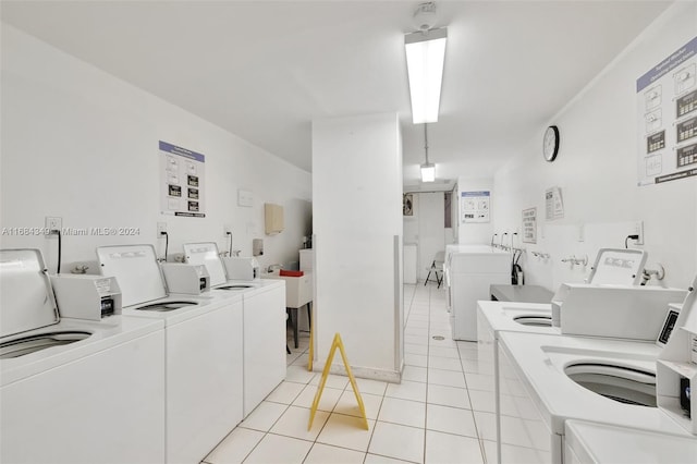 laundry area with independent washer and dryer and light tile patterned floors