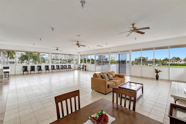 interior space featuring ceiling fan, a water view, and light tile patterned floors