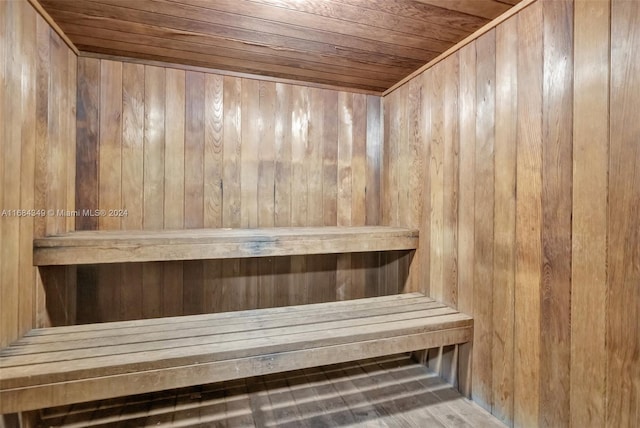 view of sauna / steam room with wood ceiling, hardwood / wood-style floors, and wood walls