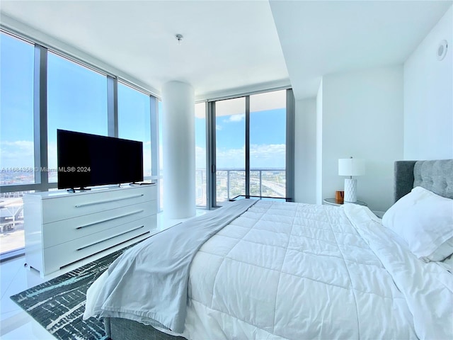 tiled bedroom featuring a wall of windows