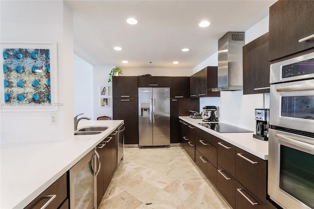 kitchen with wall chimney exhaust hood, dark brown cabinets, stainless steel appliances, sink, and wine cooler