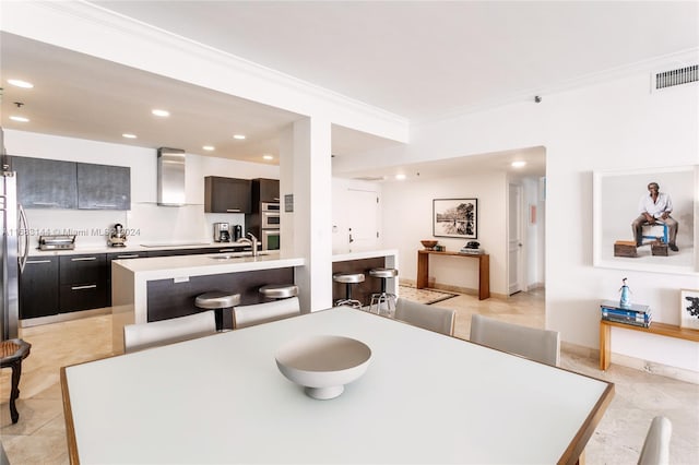 tiled dining area with crown molding and sink