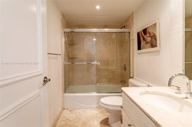 full bathroom with combined bath / shower with glass door, vanity, and toilet