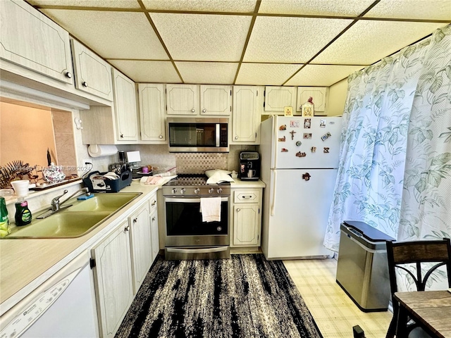 kitchen featuring a paneled ceiling, stainless steel appliances, and sink