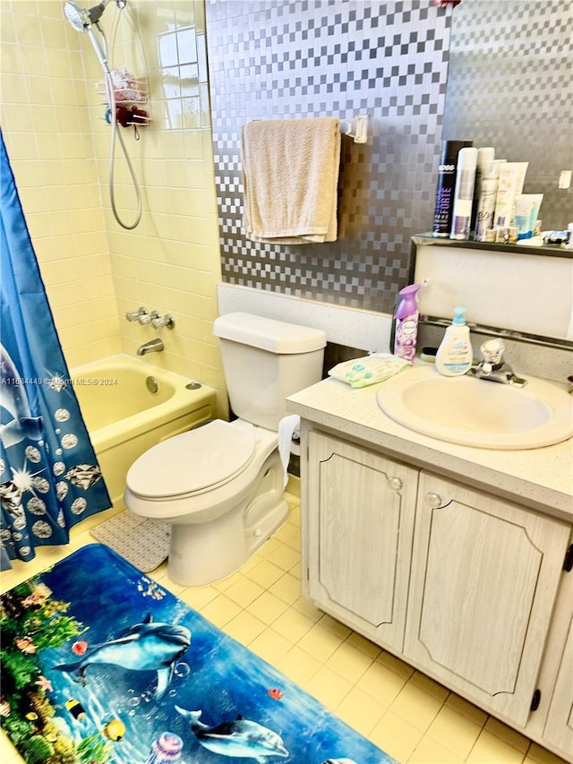 full bathroom with tile patterned floors, toilet, shower / tub combo, vanity, and tile walls