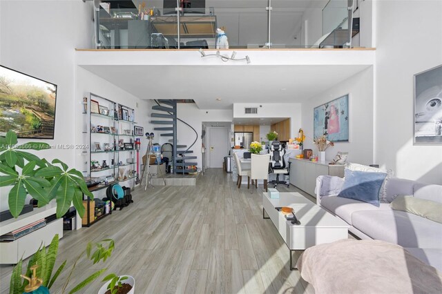 living room with a high ceiling and light hardwood / wood-style flooring