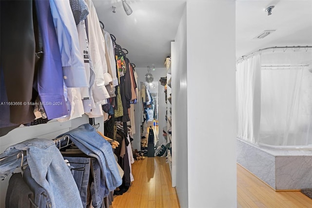 walk in closet with hardwood / wood-style flooring