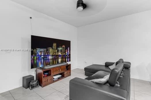 living room featuring ceiling fan and light tile patterned floors