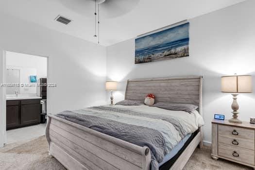 carpeted bedroom with connected bathroom and ceiling fan