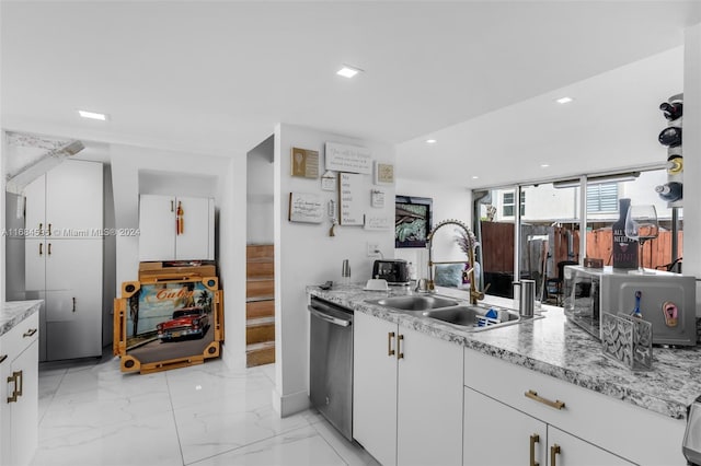 kitchen with dishwasher, light stone countertops, white cabinetry, and sink