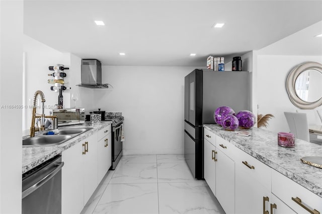 kitchen featuring white cabinets, wall chimney exhaust hood, sink, and appliances with stainless steel finishes