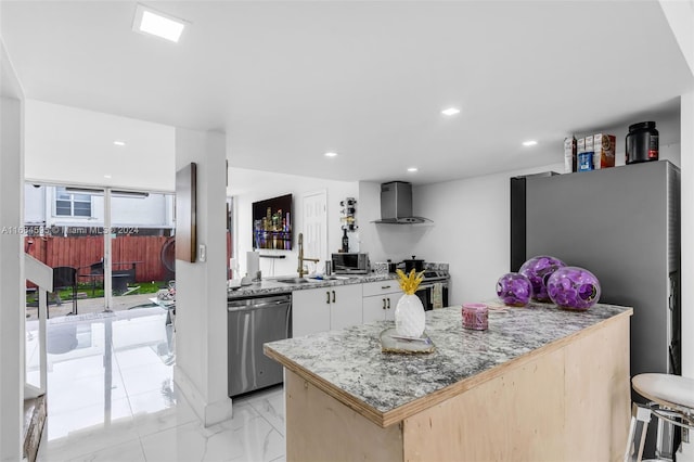 kitchen with light stone countertops, white cabinetry, sink, wall chimney exhaust hood, and stainless steel appliances