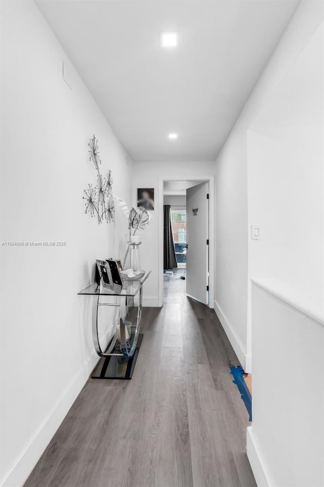hallway featuring wood finished floors and baseboards