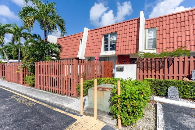 view of front of house featuring a tile roof and fence